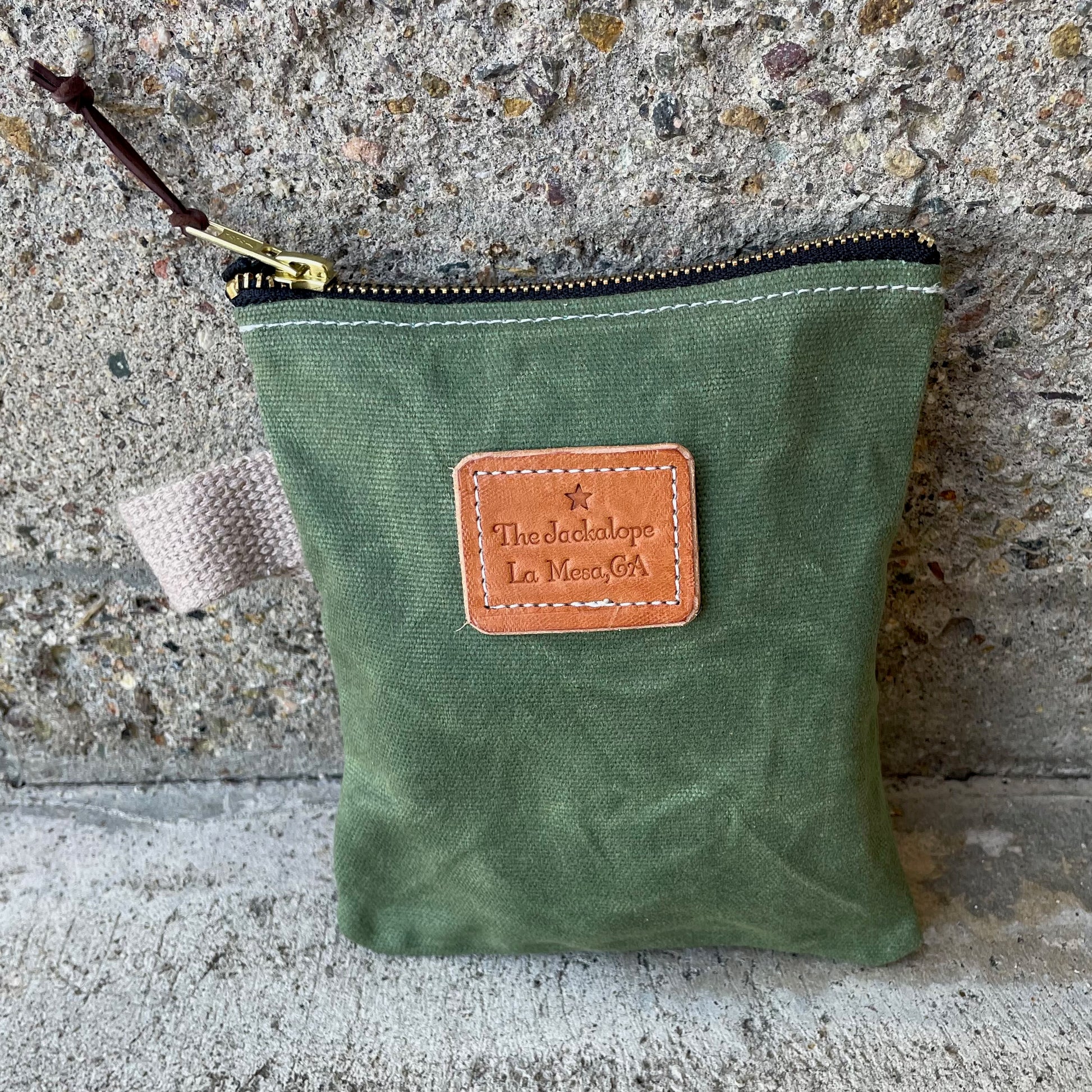 Small Ditty Bag made of waxed canvas with a zipper and a small handle.