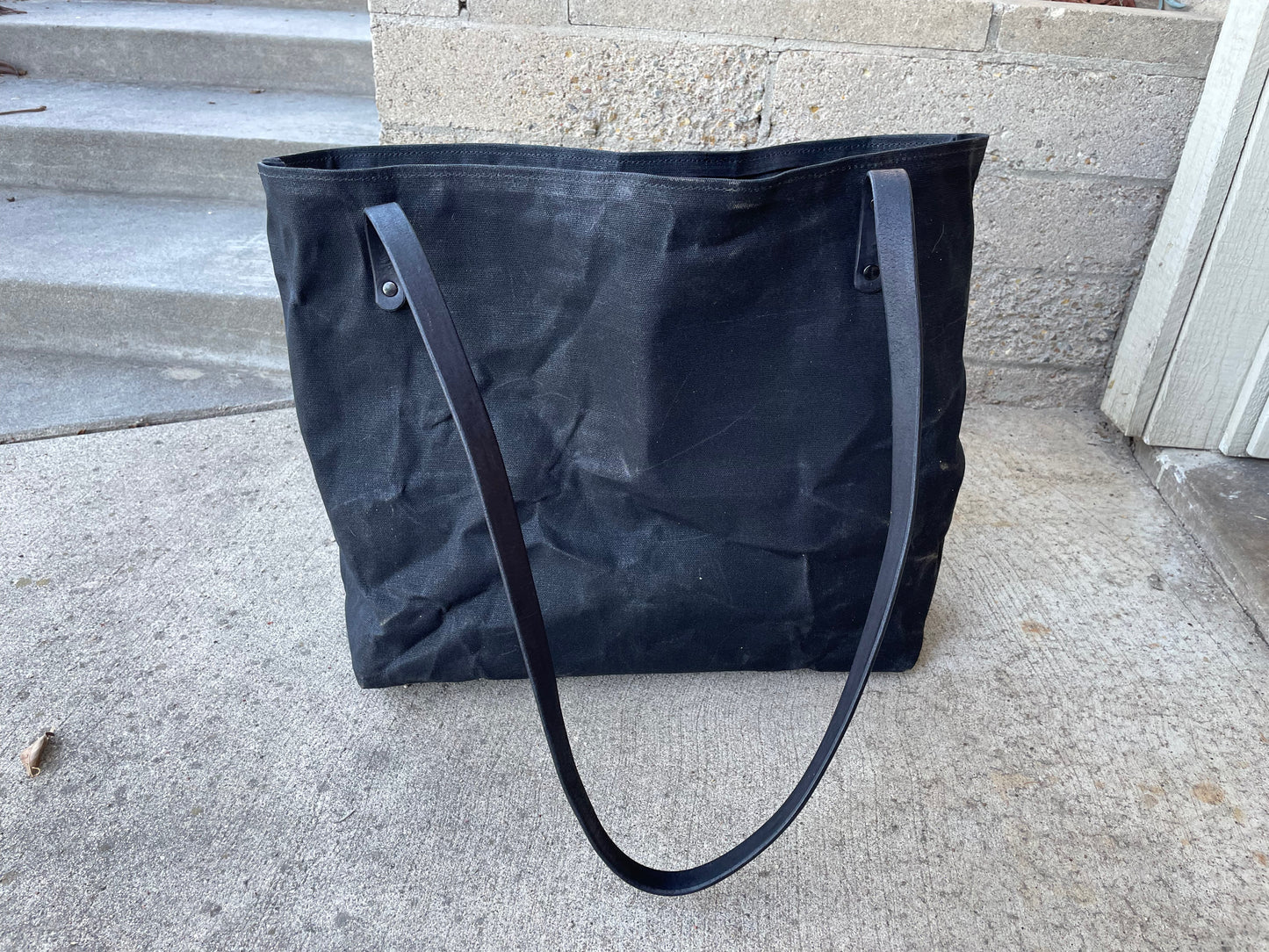 ack view of the waxed canvas market tote in the blackout colorway. 
